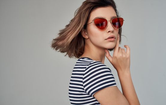 romantic woman in striped t-shirt portrait on gray background and fashionable glasses on face. High quality photo