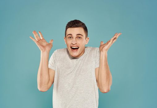 Cheerful handsome man in a white t-shirt studio blue background. High quality photo