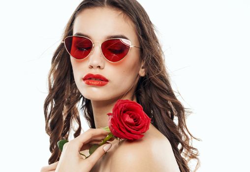 Woman model in sunglasses holding flower near face cropped view. High quality photo