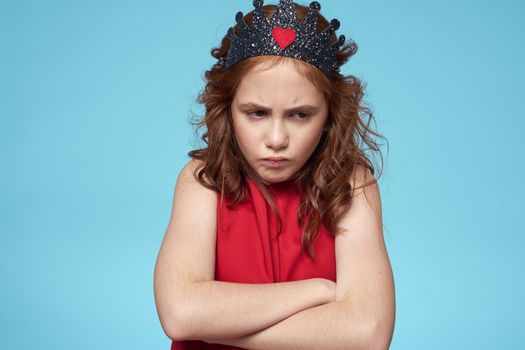 funny girl crown on her head curly hair blue background. High quality photo