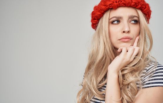 soap woman in a red hat in a striped t-shirt on a gray background blonde. High quality photo