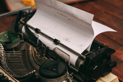 vintage typewriter with keys on a wooden background and a white sheet of paper. High quality photo