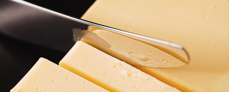 Sliced organic butter block and knife, breakfast food closeup