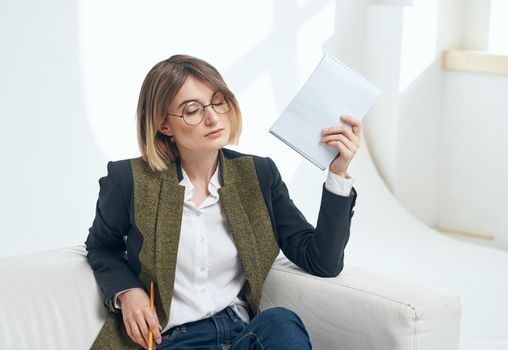 Work office woman model on the couch and papers in hand. High quality photo
