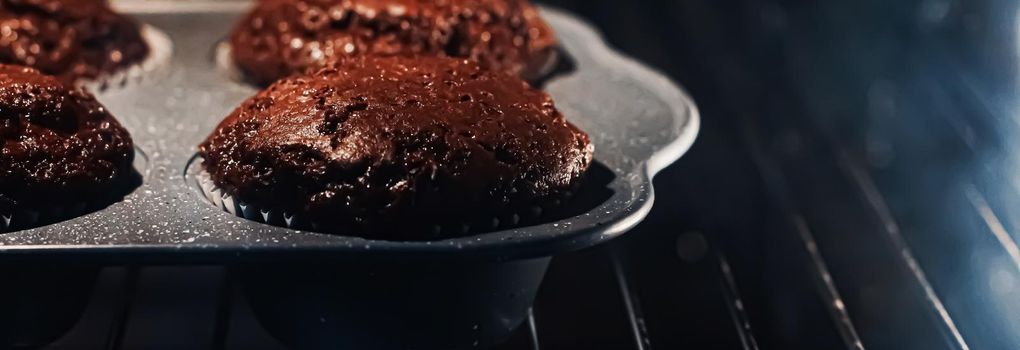 Chocolate muffins baking in the oven, homemade comfort food recipe concept