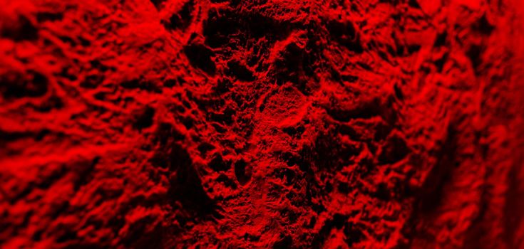 Texture of decorative plaster on concrete wall in dramatic red tonality. Abstract plaster background for design