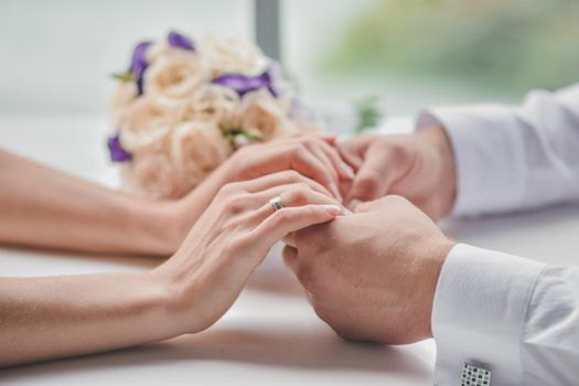 Male hands hold female hands. Man gave woman bouquet flowers. Close-up. Without a face. Selective defocusing