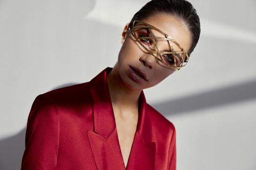 accessories on the face of a fashionable woman in a red jacket on a light background cropped view portrait. High quality photo
