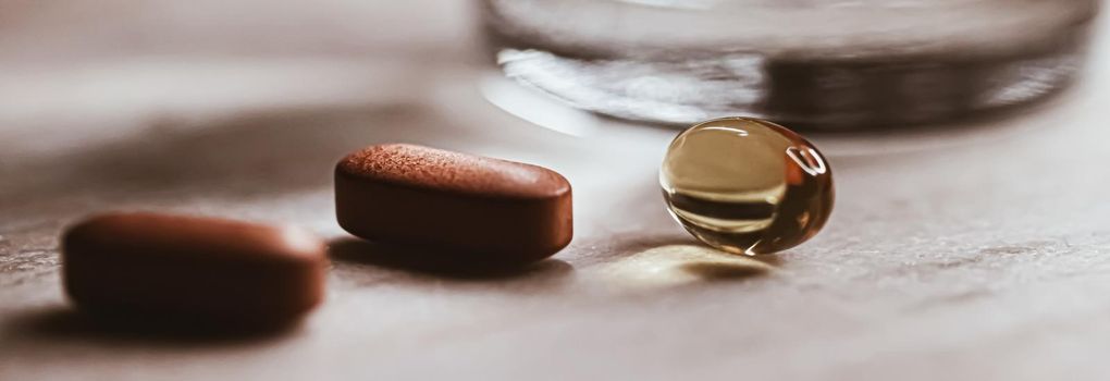 Medical pills and glass of water, health and wellness closeup