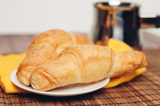 croissants in a plate on the table meal dessert for breakfast a cup of coffee. High quality photo