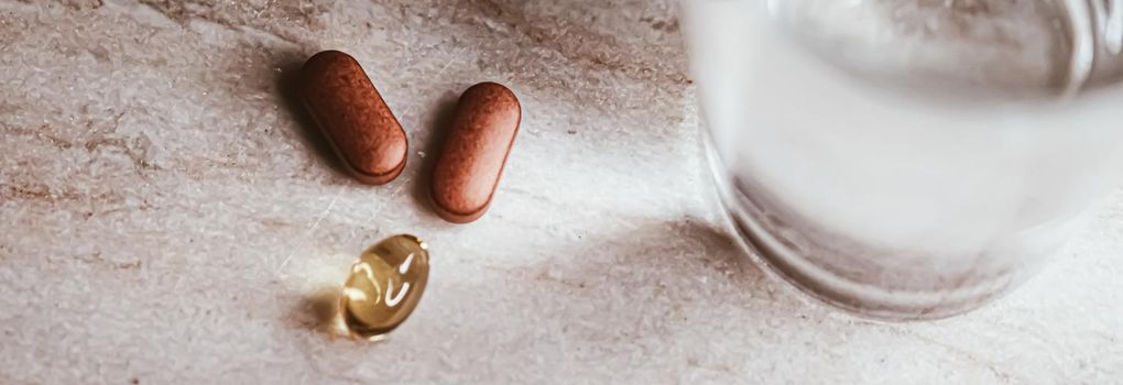 Medical pills and glass of water, health and wellness closeup