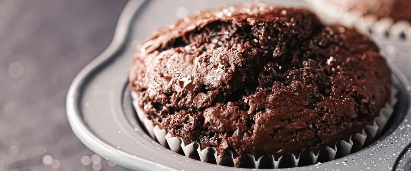 Just baked chocolate muffins in tray, homemade comfort food recipe concept