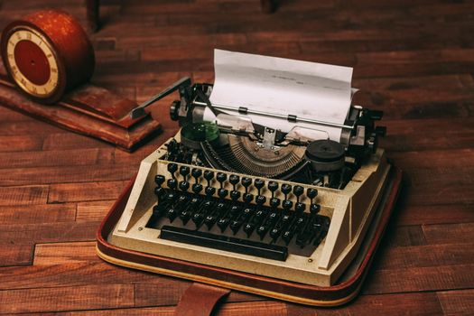 vintage typewriter with white paper stands on the floor indoors top view. High quality photo