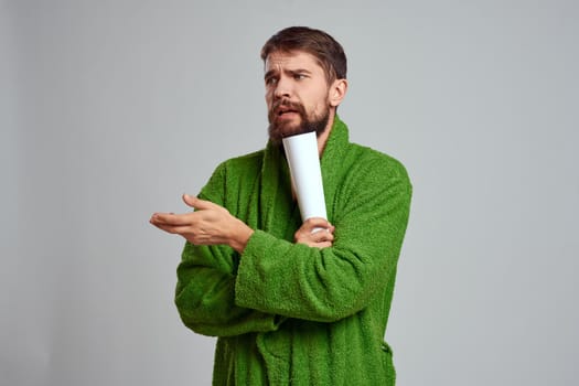 Emotional man green robe morning lifestyle gray background. High quality photo