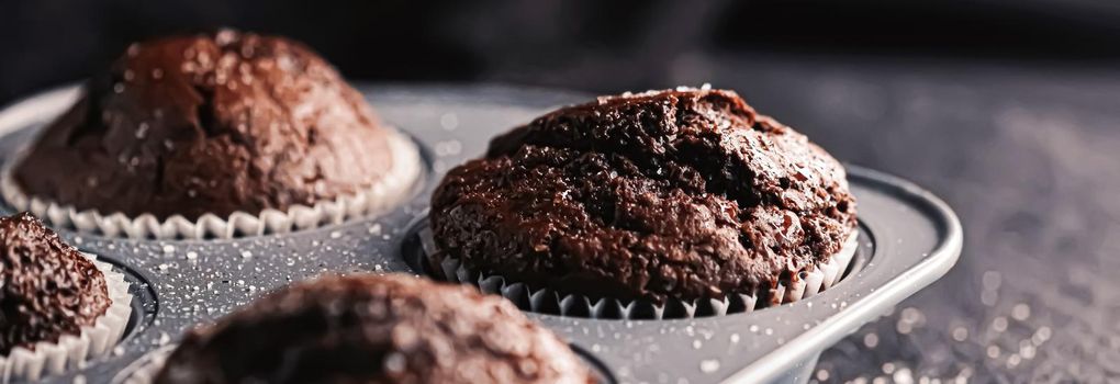 Just baked chocolate muffins in tray, homemade comfort food recipe concept