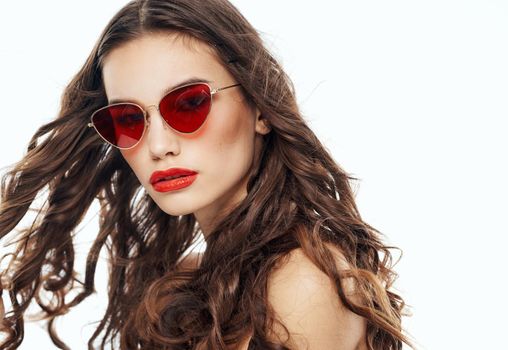 Portrait of attractive woman wearing glasses curly hair brunette light background. High quality photo