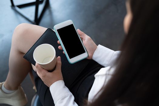 Girl using smartphone with blank screen copy space screen for your text message or information content.