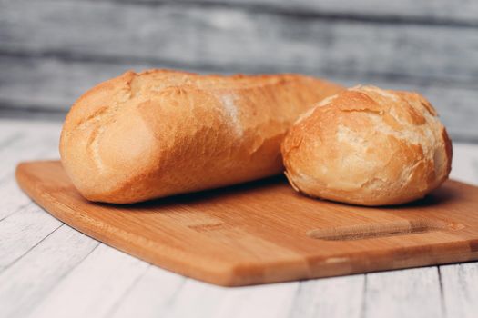 loaf with bun fresh baked goods home cooking wood board fresh flavor. High quality photo