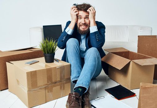 Emotional male manager unpacking lifestyle boxes in office. High quality photo