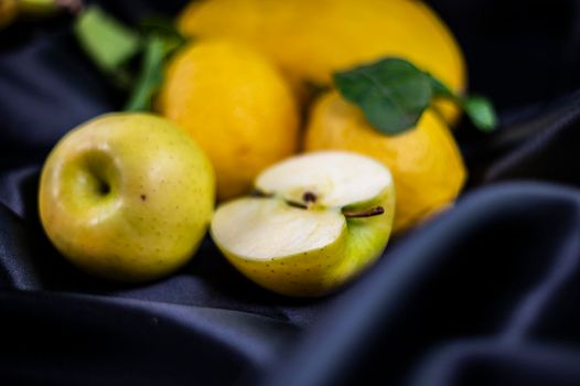 yellow fruit on a black background with melon bananas apples and lemons