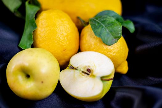 yellow fruit on a black background with melon bananas apples and lemons