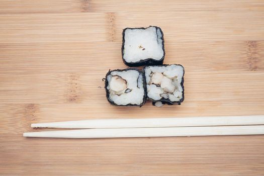 sushi rolls chopsticks wooden board top view. High quality photo