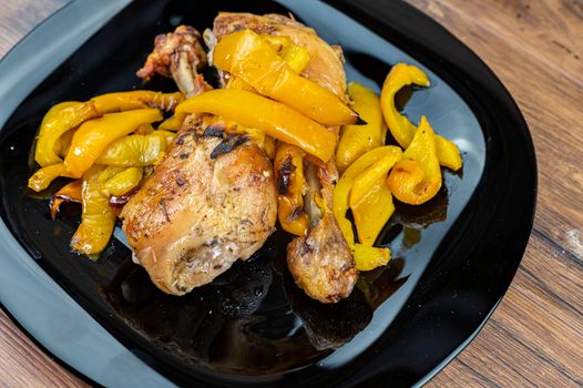 so of chicken with yellow peppers glass of red wine on wooden table