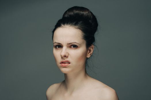 beautiful brunette with bare shoulders on gray background cropped view. High quality photo