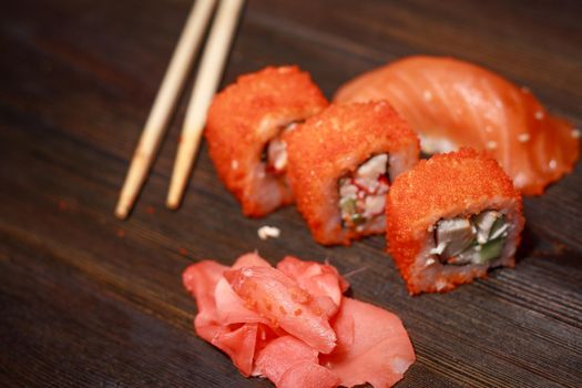 delicacy sushi and rolls on the table wooden sticks ginger wasabi top view. High quality photo