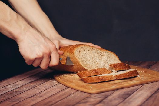 cutting a fresh loaf on a cutting board crispy bread. High quality photo