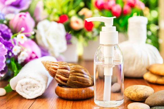 Spa concept,Snail and Bottle collagen or serum oil, Thai Spa massage setting with bottle with essential oil and thai herbal compress balls