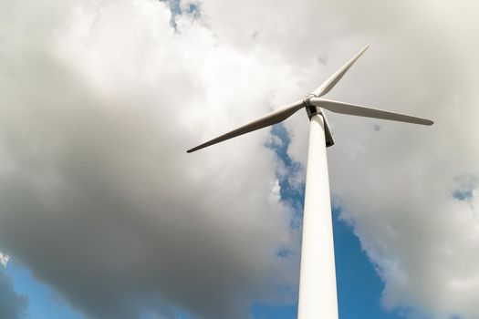 Close up Wind turbine  generators against a cloudy blue sky