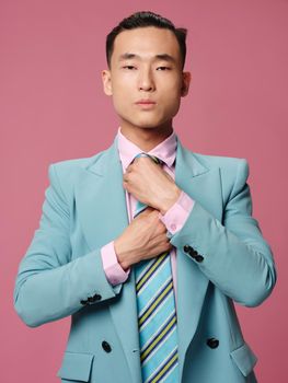 Man of Asian appearance blue suit executive draw office pink background . High quality photo