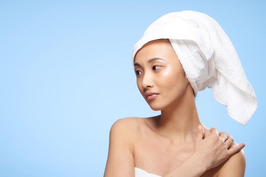 pretty asian woman clean skin care towel on head blue background. High quality photo