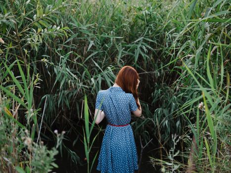 Woman outdoors near green grass and a river in the background. High quality photo