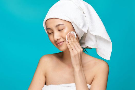 woman with bare shoulders clean skin towel on head blue health background. High quality photo