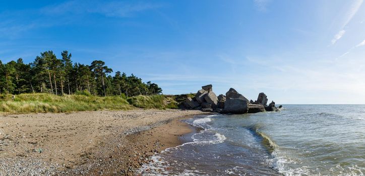 Demolished military fortifications in Liepaja, Latvia. Baltic sea coastline with pine trees and clouds. Classical Baltic beach landscape.