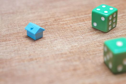 Symbol house investment risks insurance real estate mortgage home game dice. Property risks and chances concept. Miniature house and dice on wood background mortgage loans real estate taxes and debts