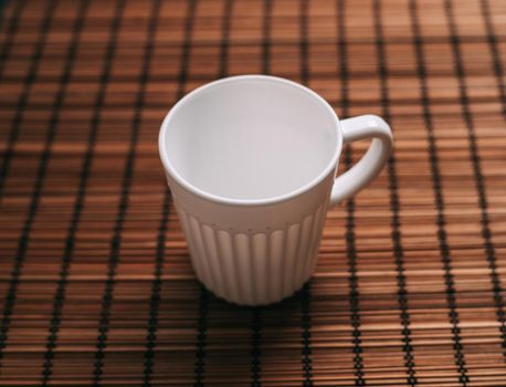 white mug on a wooden stand stands on the table top view. High quality photo