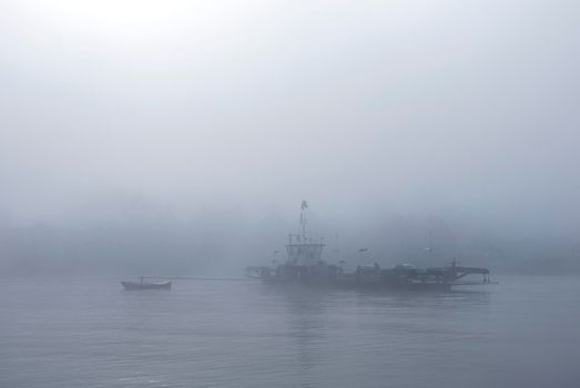 ferry in the mist on river lek near culemborg and utrecht in the netherlands