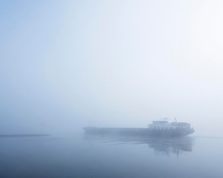 barge in the fog on river rhine near utrecht in the netherlands