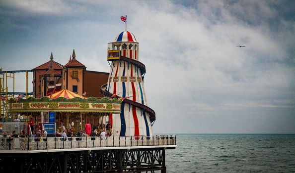 Wide-shot of the helter skelter and carousel at Brighton Pier