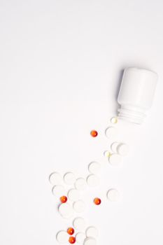 White jar with pills on a light background top view medicine health vitamins. High quality photo