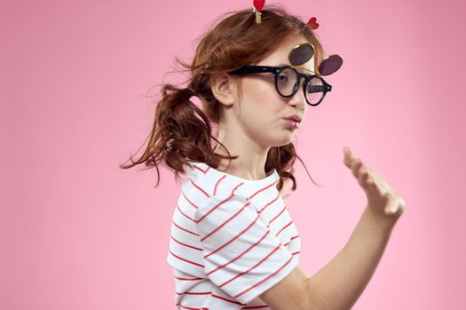 Fashionable girl with clothespins in the form of hearts on her head and glasses on her face. High quality photo