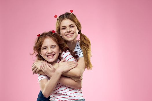 Woman and little girl on a pink background fun sisters friends family. High quality photo