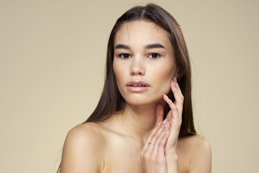 Pretty woman naked shoulders long hair body care beige background. High quality photo