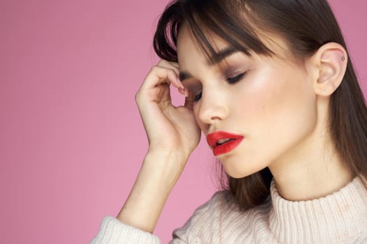 Beautiful brunette red lips white blouse close-up attractive view pink background. High quality photo