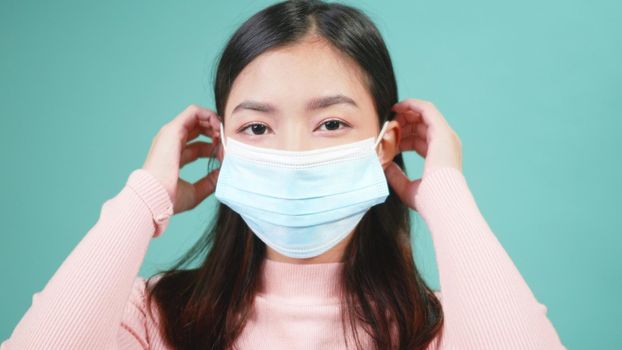 Close up portrait young Asian happy beautiful woman wearing anti virus protection face mask. Female wear sterile medical mask, Coronavirus outbreak protection healthcare concept