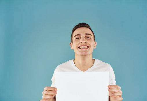 Handsome guy with white sheet of paper advertising mockup Copy Space. High quality photo
