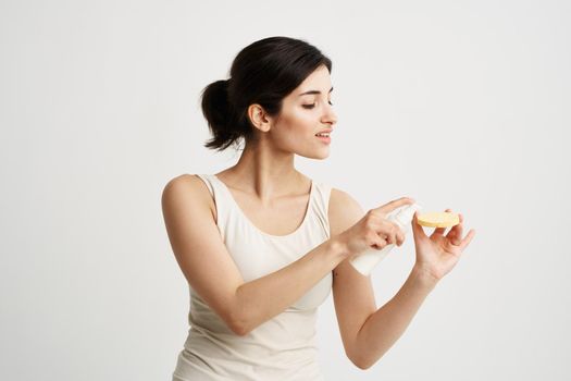 Beautiful brunette in a white T-shirt Sponge in the hands of skin care. High quality photo